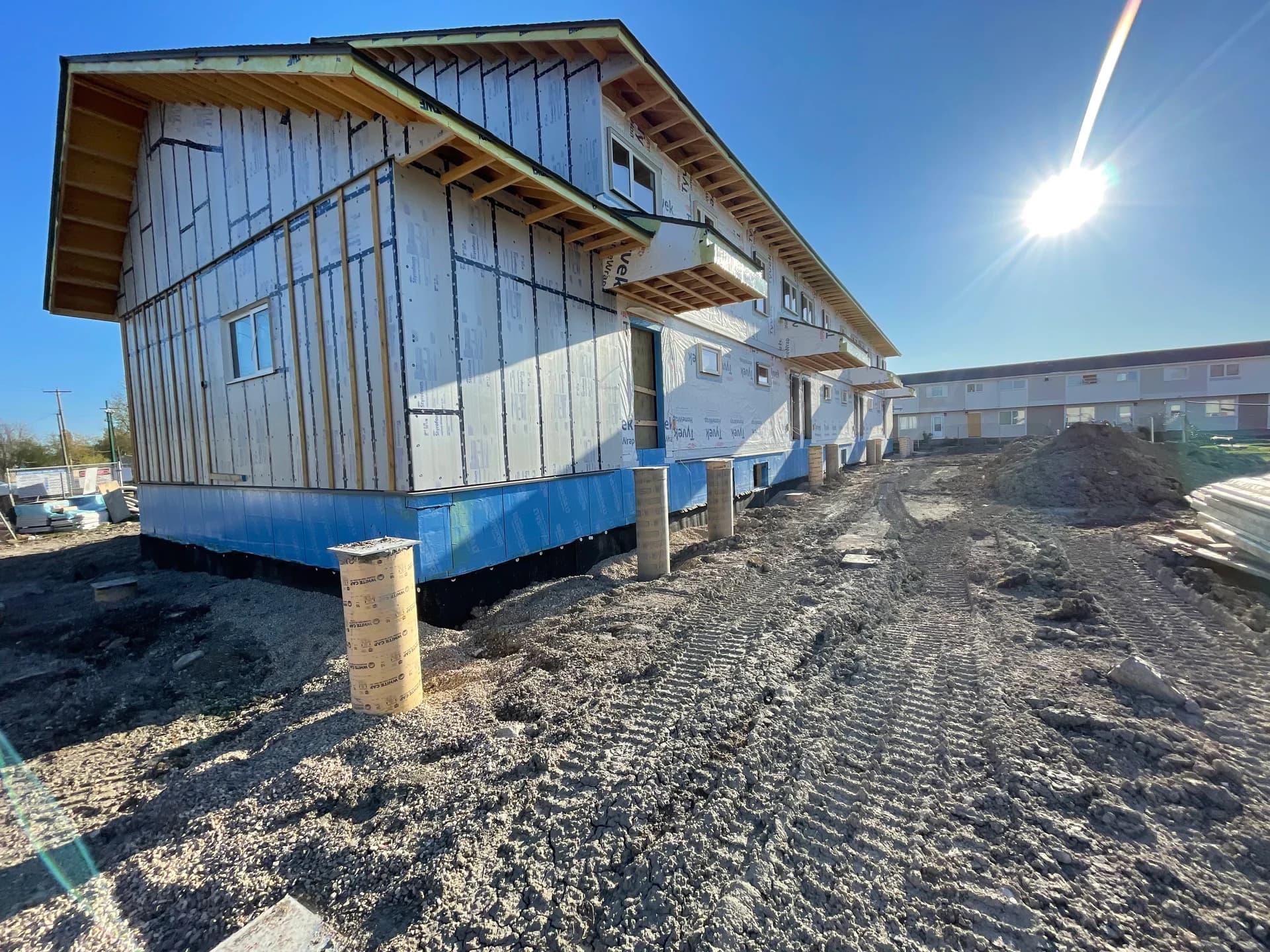 Kelsey Estates townhomes under construction in The Pas, with building wrap and site grading in progress