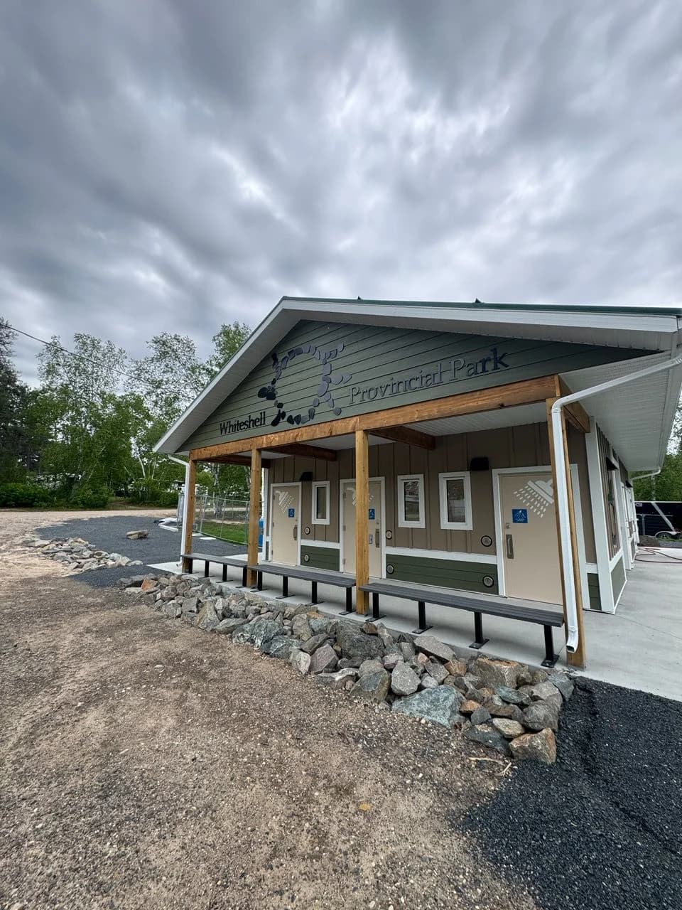 West Hawk Lake washroom and shower building with a covered entrance, accessible doors and Whiteshell Provincial Park signage